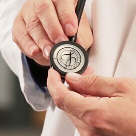 Un médecin tenant un drapeau d'un stéthoscope 3M Littmann avec un sceau Littmann sur le diaphragme.