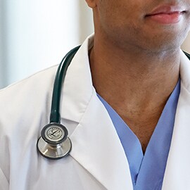 Stéthoscope Littmann sur le col d'une blouse blanche pour que le câble ne touche pas le cou.